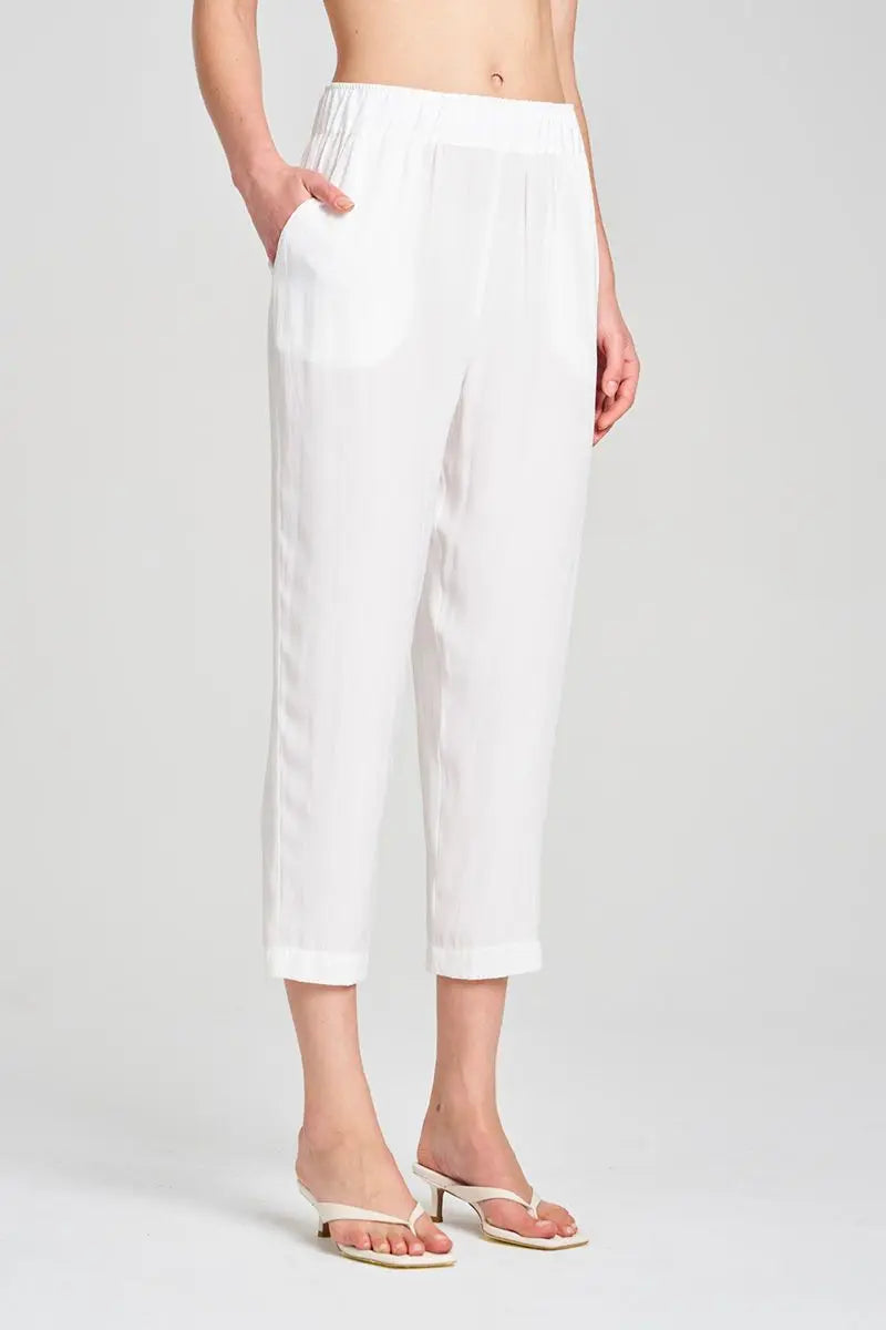 Person wearing white pants on a plain background