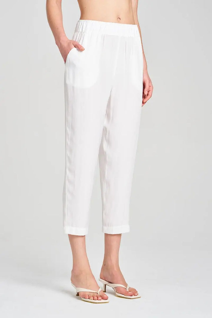 Person wearing white pants on a plain background