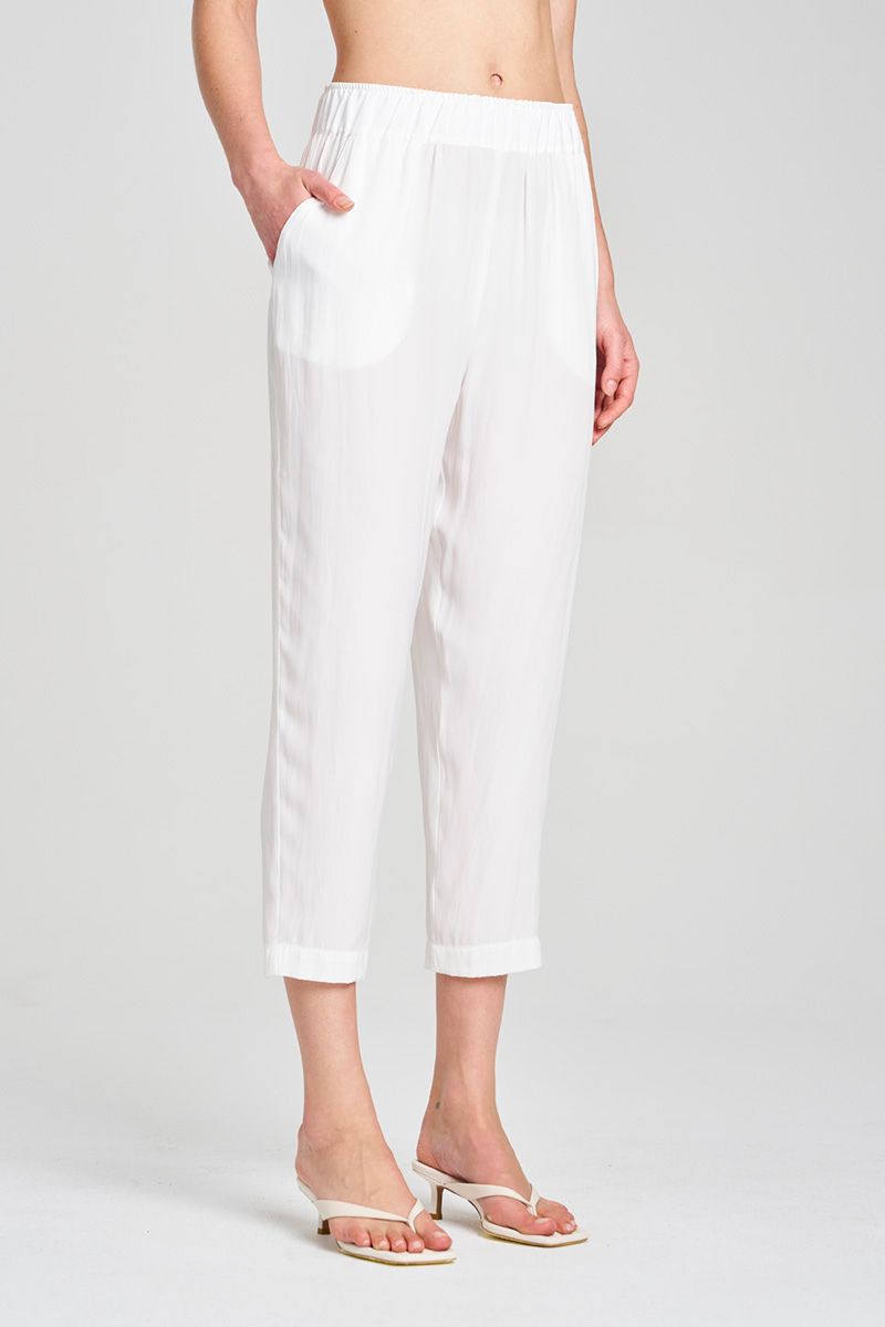Person wearing white pants on a plain background