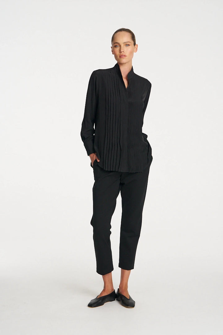 Woman wearing Mela Purdie Balcony Blouse F67 8970 in Black, with black cropped trousers and flat shoes
