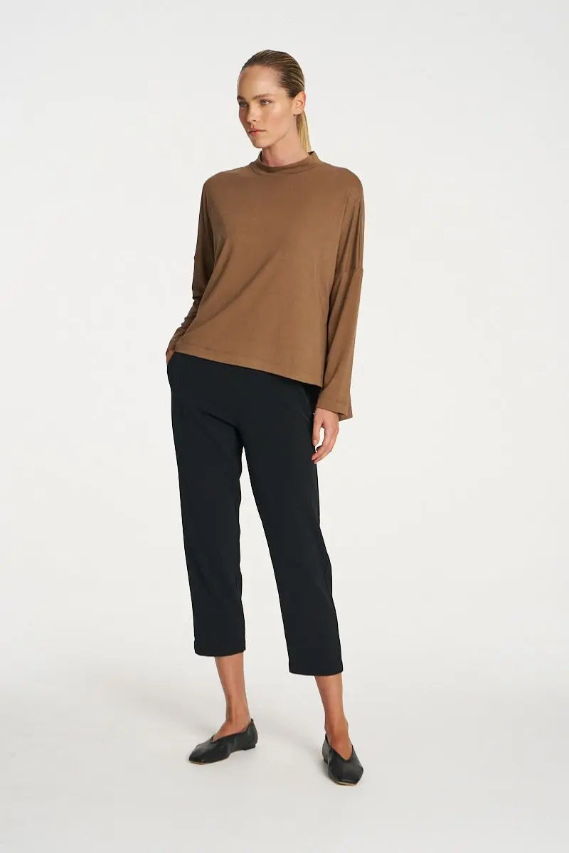 Woman wearing Tapered Flat Pant in Black by Mela Purdie front