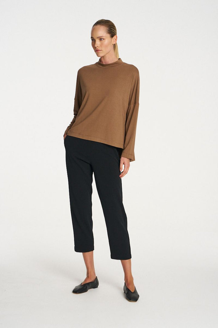 Woman wearing Tapered Flat Pant in Black by Mela Purdie front