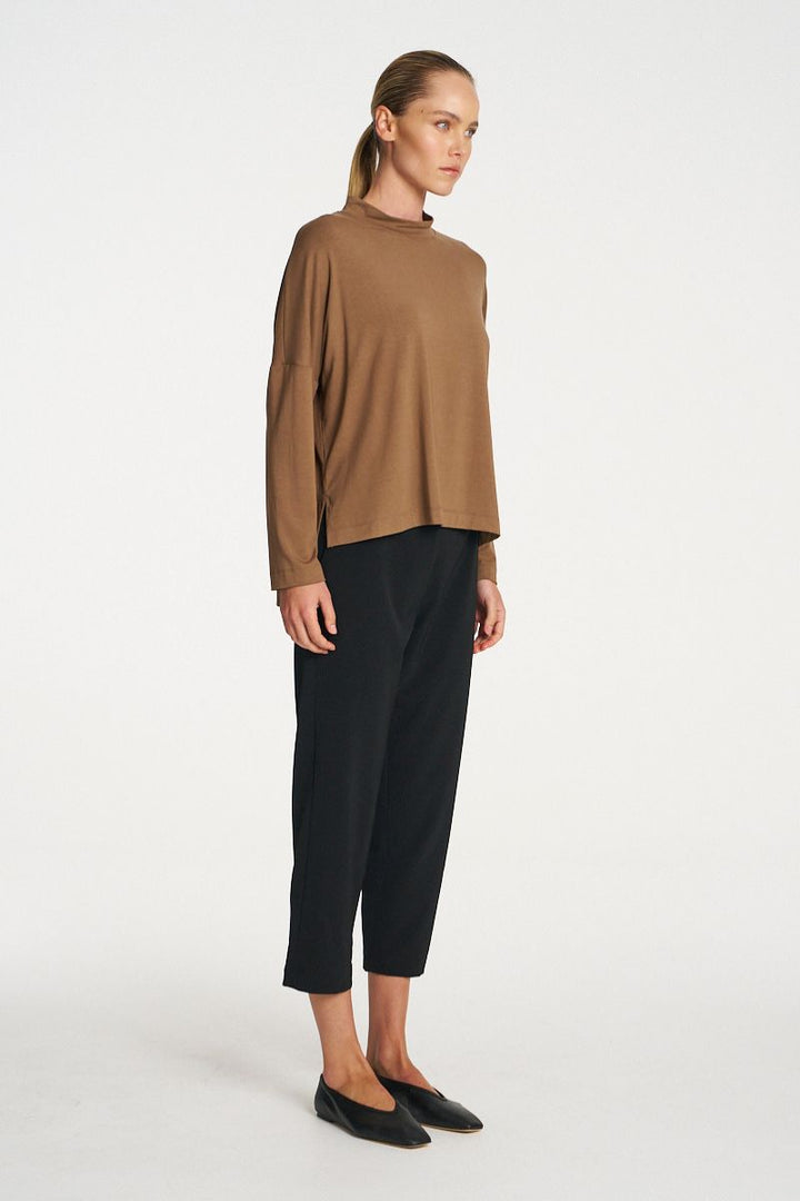 Woman wearing Tapered Flat Pant in Black by Mela Purdie side