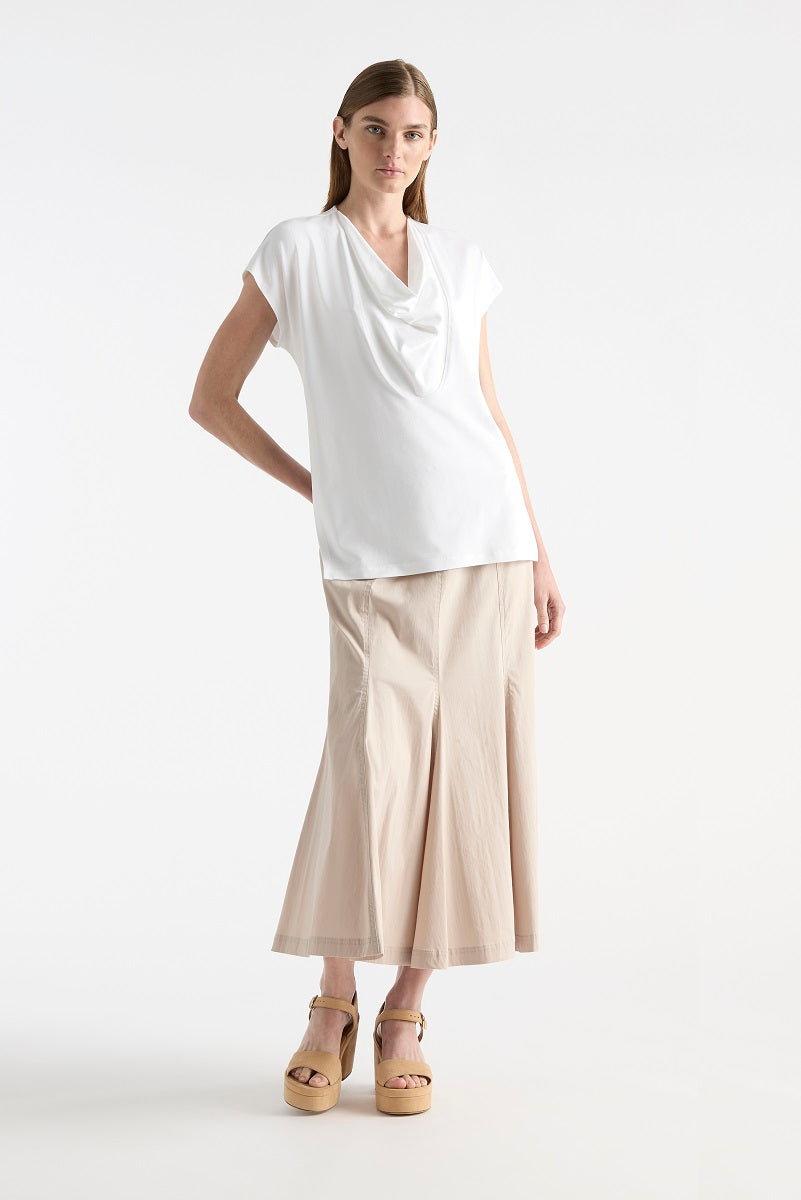 Woman wearing Fluid Shell in White by Mela Purdie F01 8369, front view, with a neutral midi skirt and platform sandals.