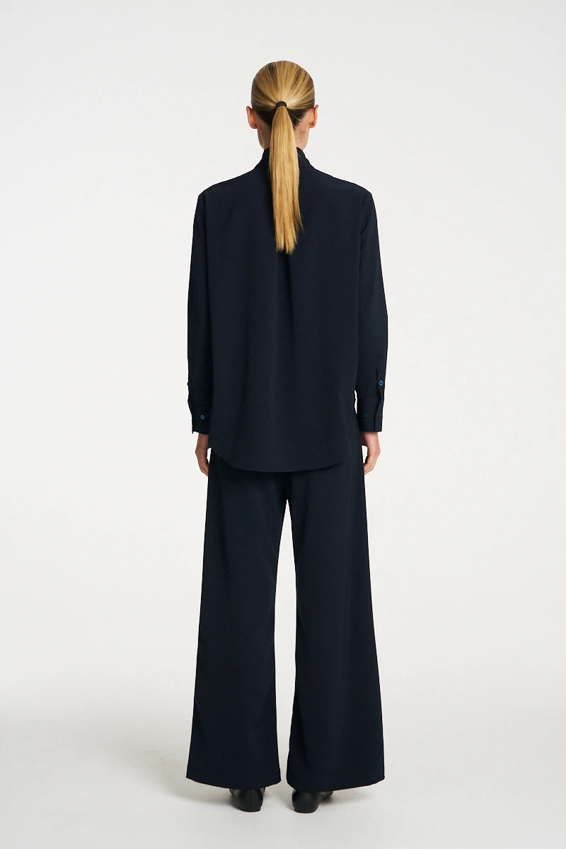 Woman wearing Mela Purdie Formal Shirt F618 8956 in Black, back view showing the centre-back pleat