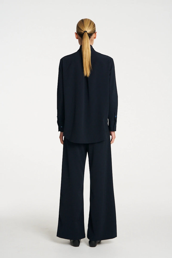 Woman wearing Mela Purdie Formal Shirt F618 8956 in Black, back view showing the centre-back pleat