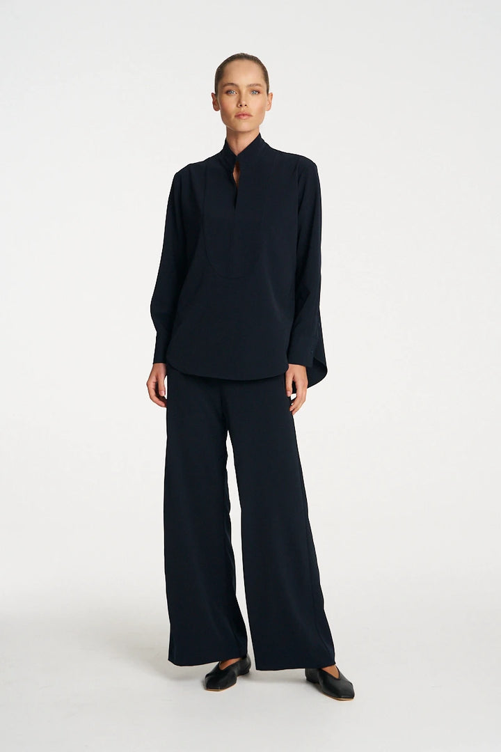 Woman wearing Mela Purdie Formal Shirt F618 8956 in Black, with matching wide-leg trousers, outfit front view
