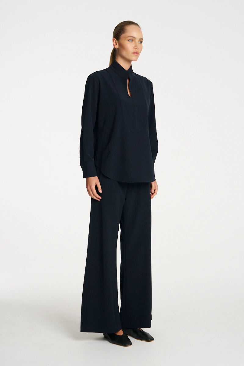 Woman wearing Mela Purdie Formal Shirt F618 8956 in Black, side view showing the curved hem