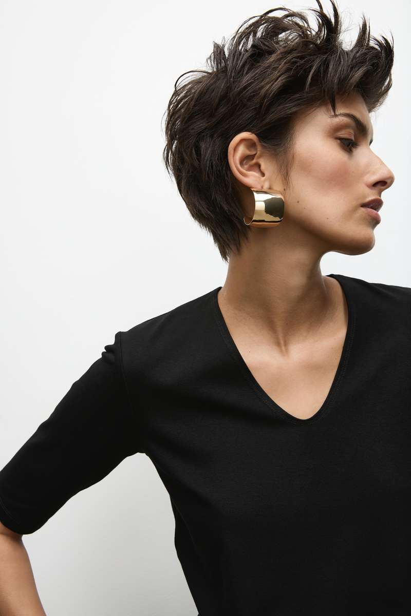 Woman wearing a black Mela Purdie V-neck top, close-up outfit detail from the Long Pant F01 100 gallery.
