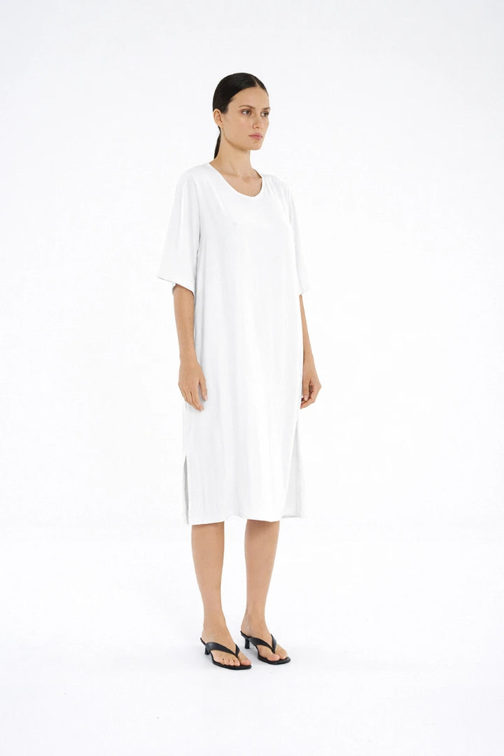 Woman wearing Mela Purdie Plaza Dress F67 3004 in White, side view