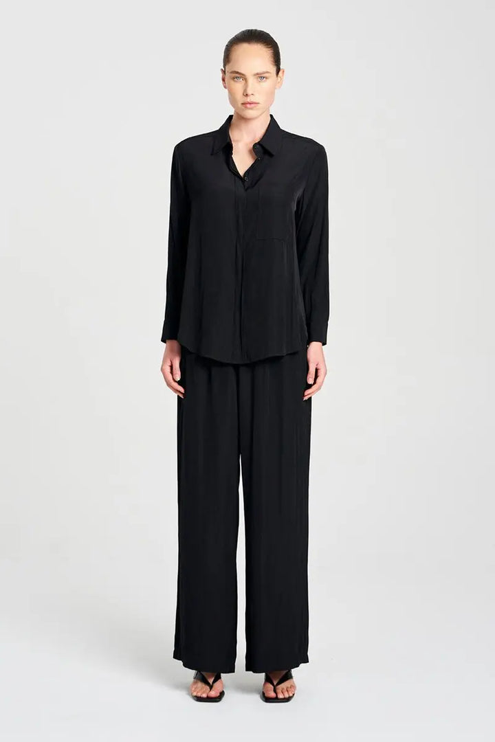 Woman wearing Mela Purdie Single Pocket Shirt F67 7741 in Black, with matching wide-leg trousers and heeled sandals