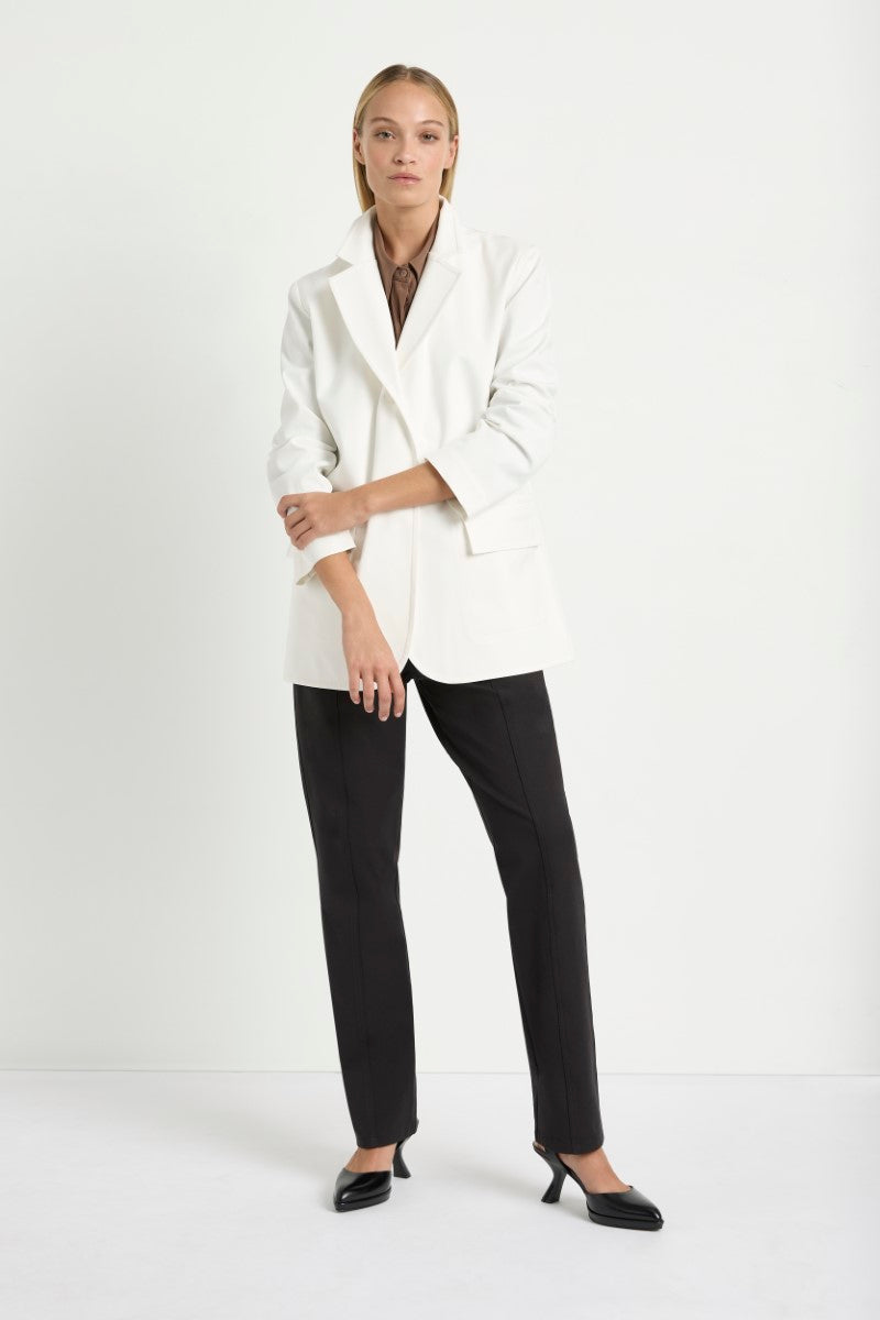 Woman wearing Stretch Blazer in Ivory by Mela Purdie F414 4129, front view with the sleeve cuff turned back.