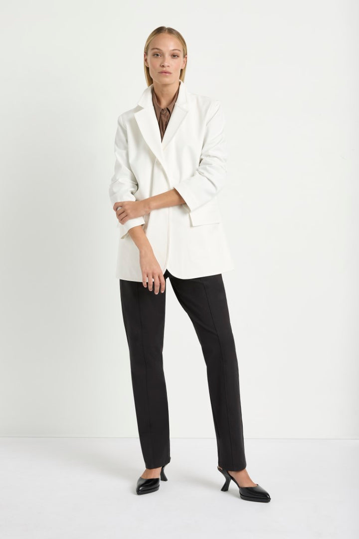 Woman wearing Stretch Blazer in Ivory by Mela Purdie F414 4129, front view with the sleeve cuff turned back.