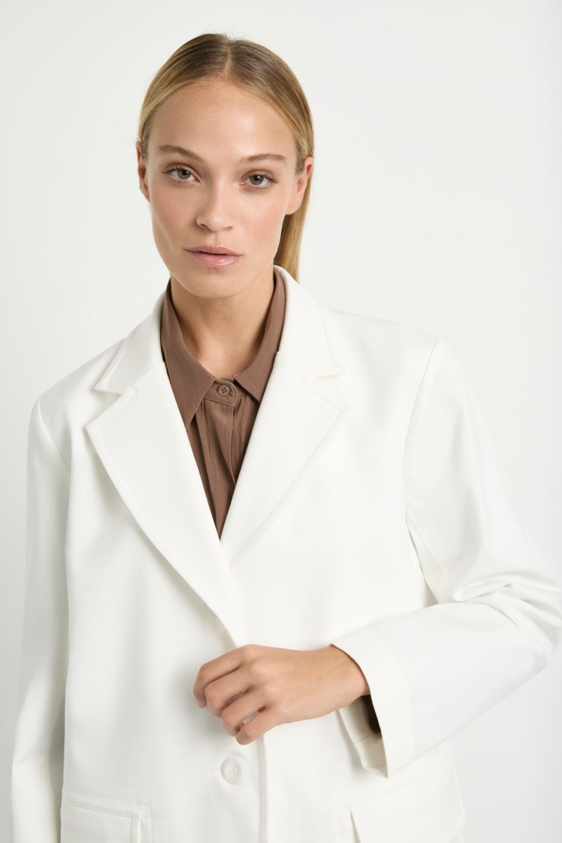 Woman wearing Stretch Blazer in Ivory by Mela Purdie F414 4129, front close-up showing the lapels and button fastening.