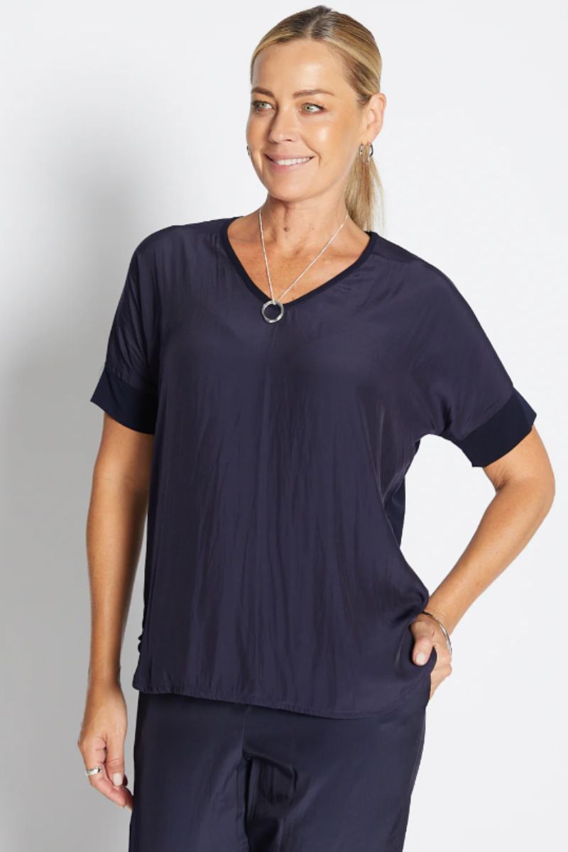 Woman wearing a navy blue top and pants on a white background