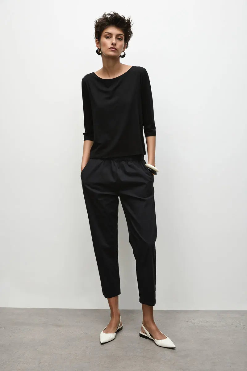 Woman wearing Nomad Pant in Microprene F65 1478 by Mela Purdie in Black, front view with hands in the pockets.