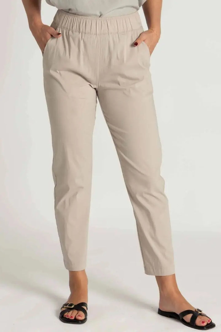 Woman wearing Nomad Pant in Microprene F65 1478 by Mela Purdie in Putty, front detail of the elasticated waist and tapered leg.