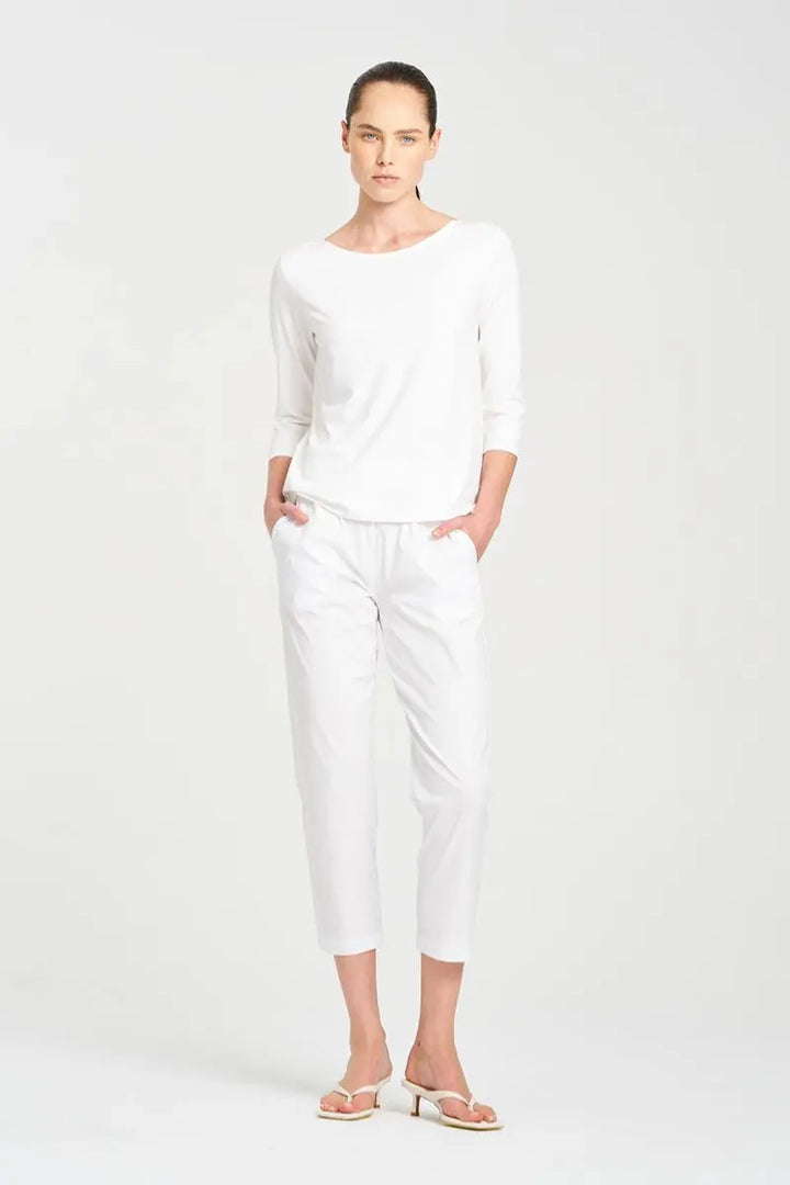 Woman wearing Nomad Pant in Microprene F65 1478 by Mela Purdie in White, front view with a boat-neck top.