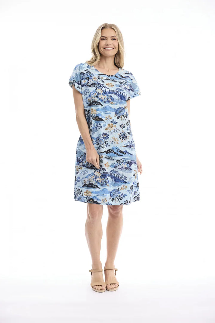 Woman wearing Orientique Nanjing Reversible Dress 61061 in blue floral print on white studio background