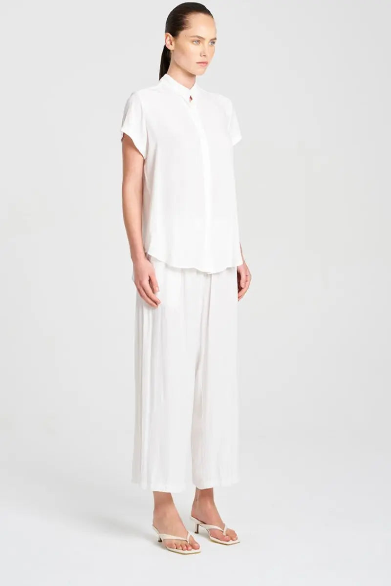 Woman wearing a white outfit on a plain background