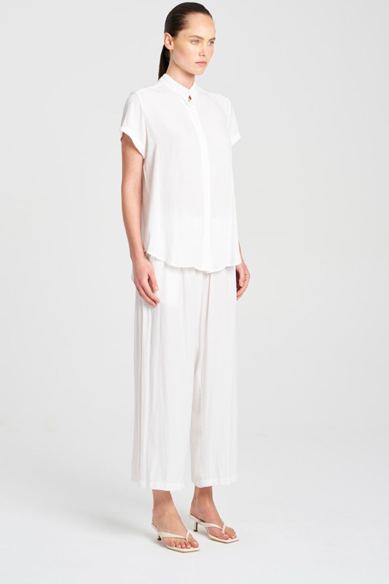 Woman wearing a white outfit on a plain background