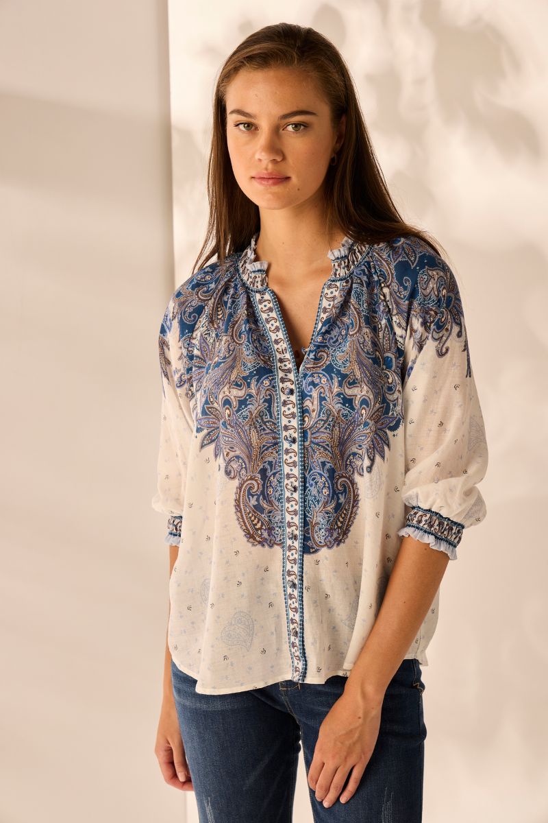 Shirt in Payton Print White with Blue Pattern By Lania the Label Woman wearing a patterned blouse with a plain background