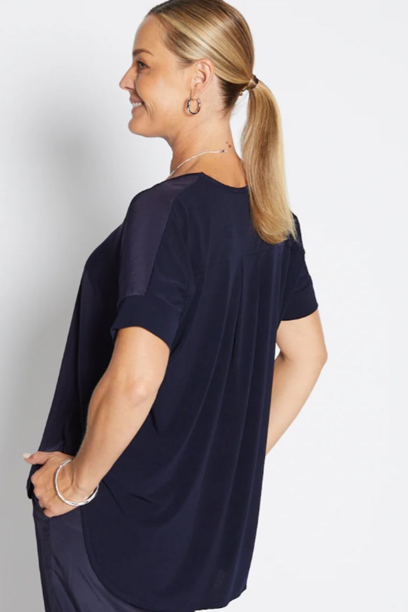 Back view of Woman wearing a navy blue oversized t-shirt on a white background