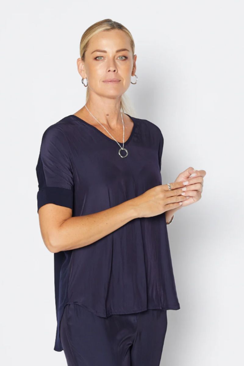 Woman wearing a navy blue outfit against a white background