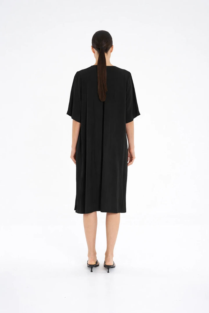 Woman wearing Plaza Dress in Black by Mela Purdie F67 3004, back view showing the centre-back pleat.