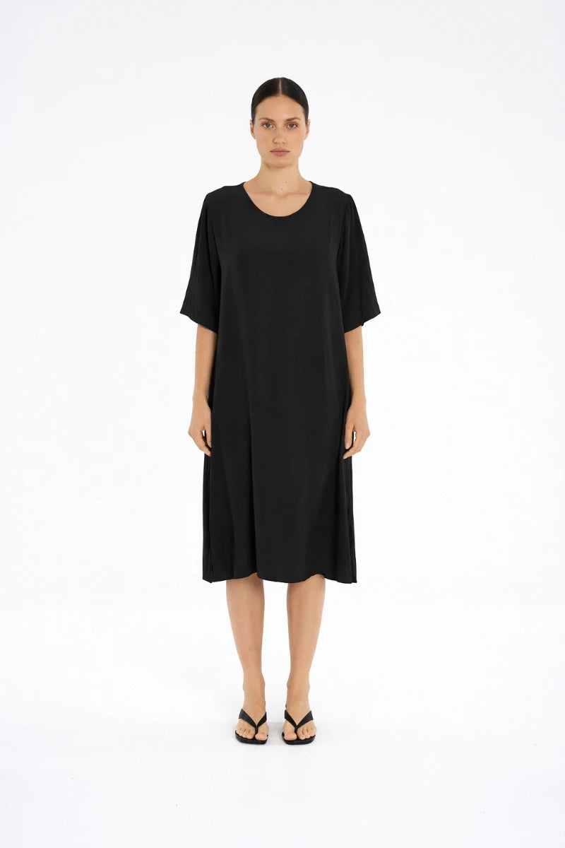 Woman wearing Plaza Dress in Black by Mela Purdie F67 3004, front view.