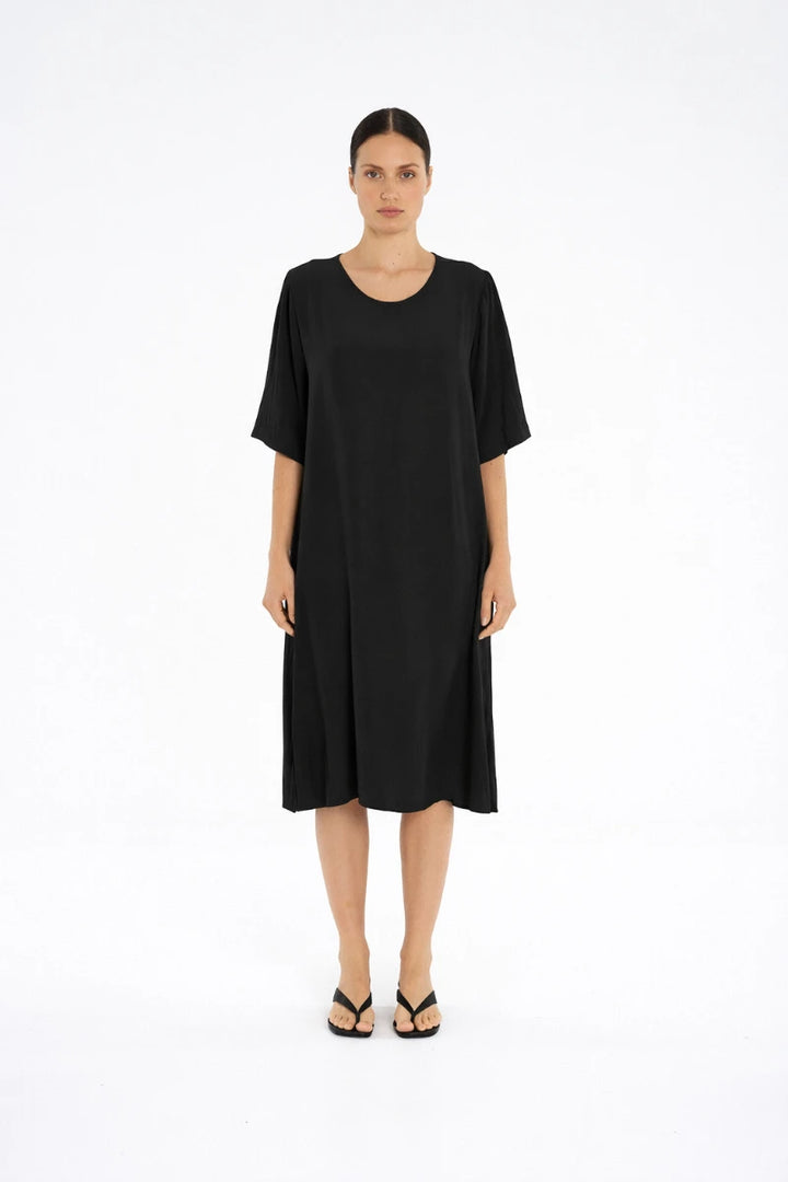 Woman wearing Plaza Dress in Black by Mela Purdie F67 3004, front view.