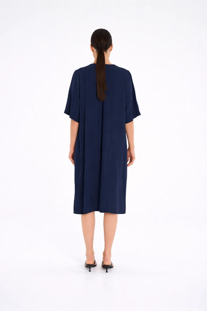 Woman wearing Plaza Dress in Navy by Mela Purdie F67 3004, back view.
