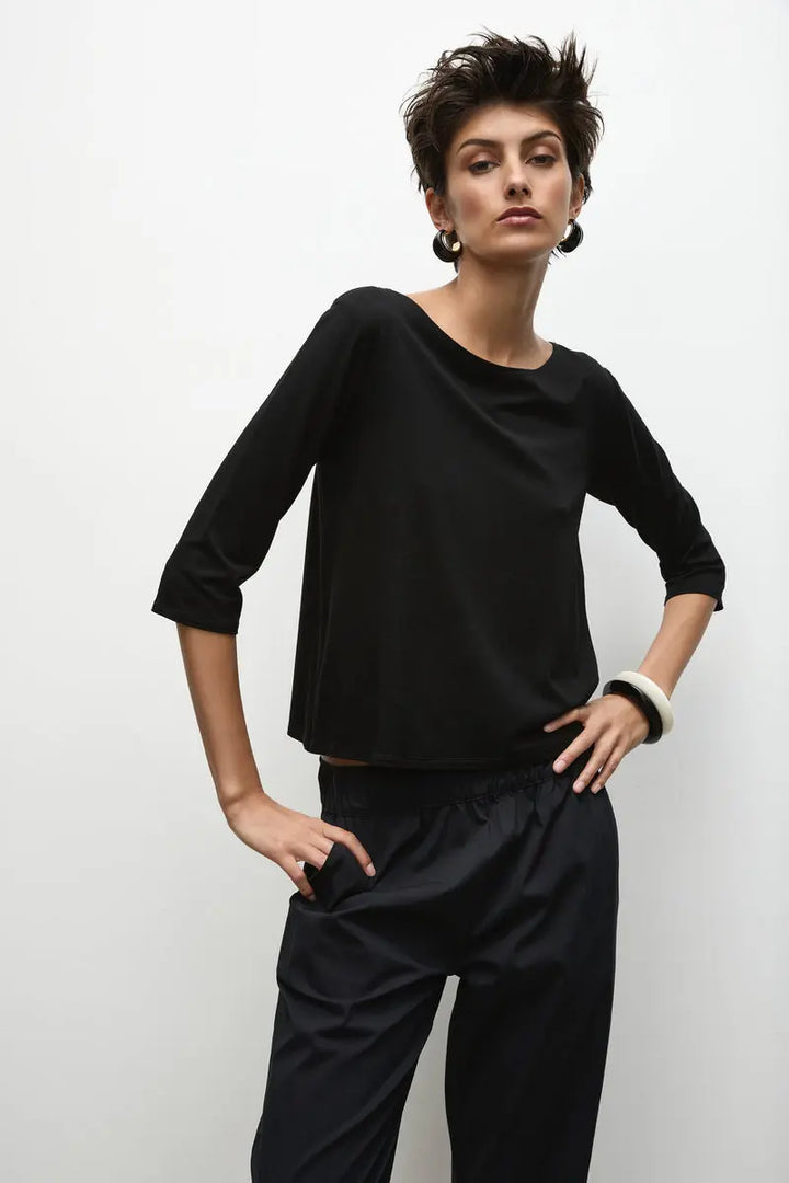 Woman wearing Relaxed Boat Neck in Matte Jersey F01 2630 by Mela Purdie in Black, front view with hands at the hips.