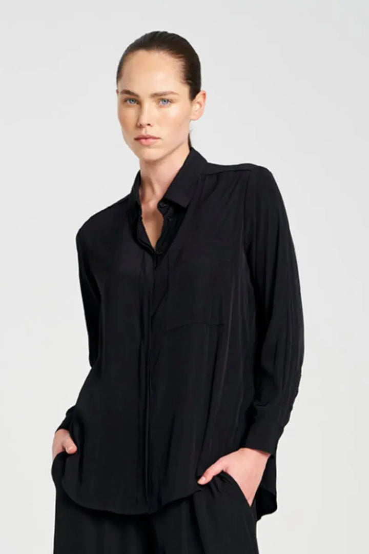 Woman wearing a black shirt against a plain background