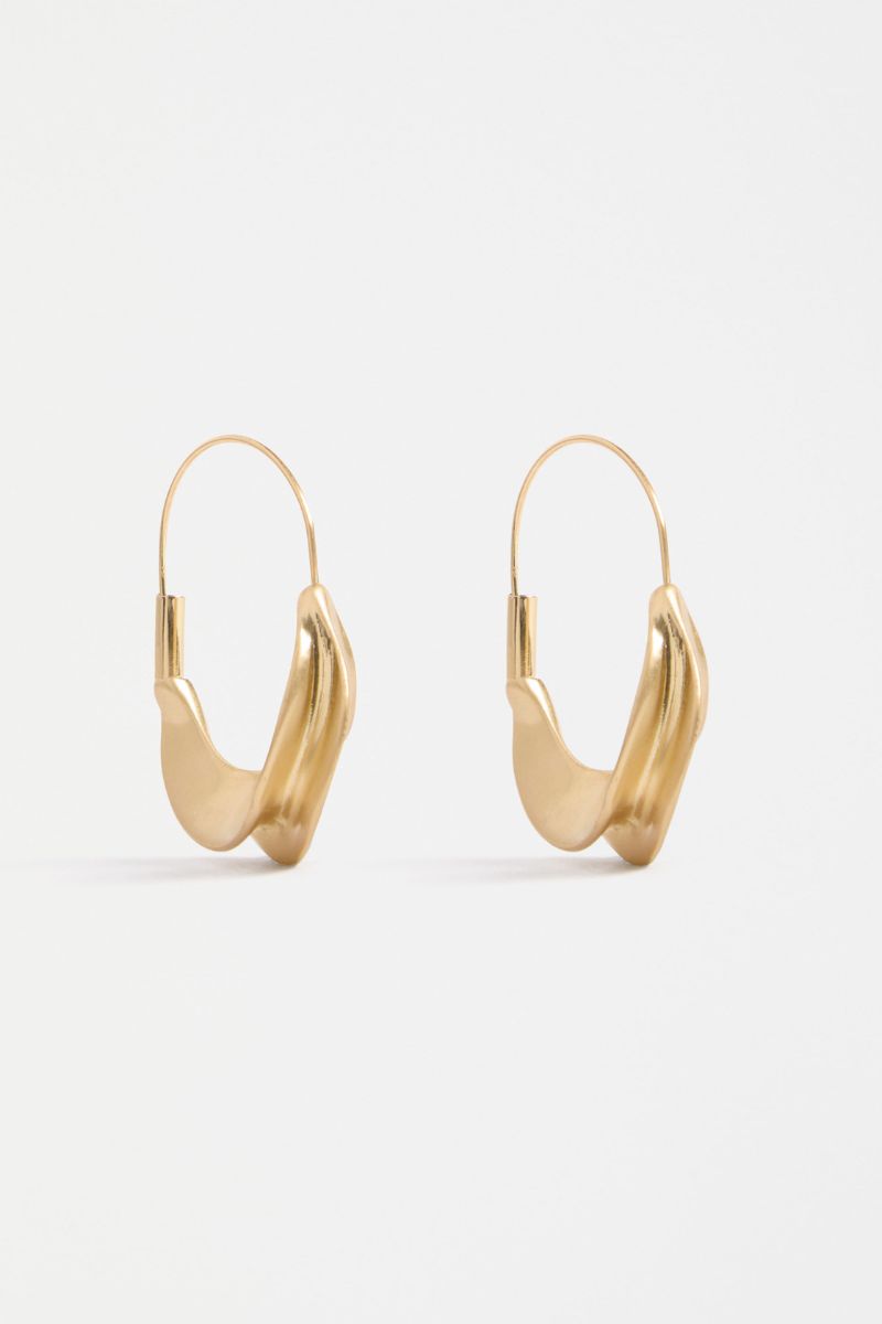 Gold hoop earrings on a light gray background