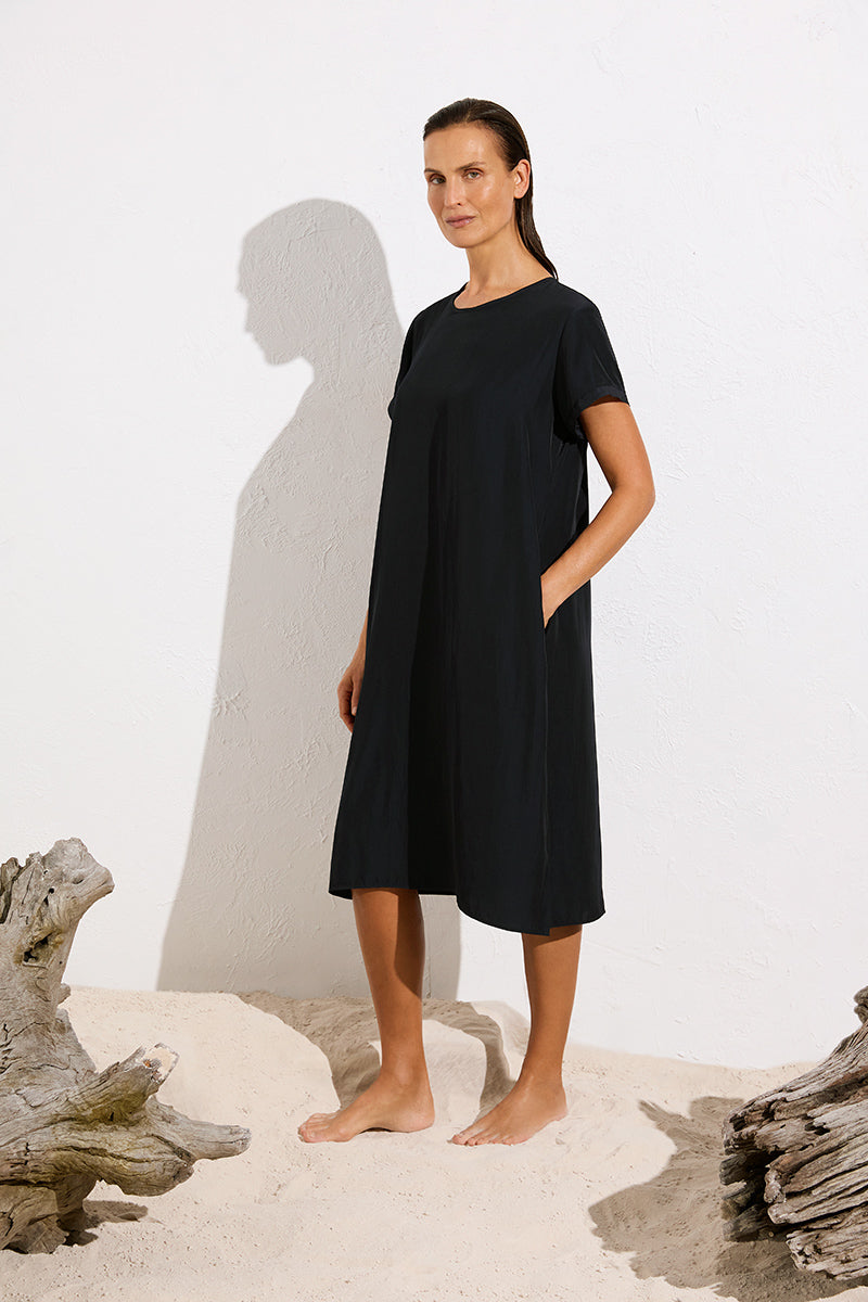 Woman wearing Travel T Dress in Maché F67 3203 by Mela Purdie in Black, side outdoor view showing the side-seam pocket.