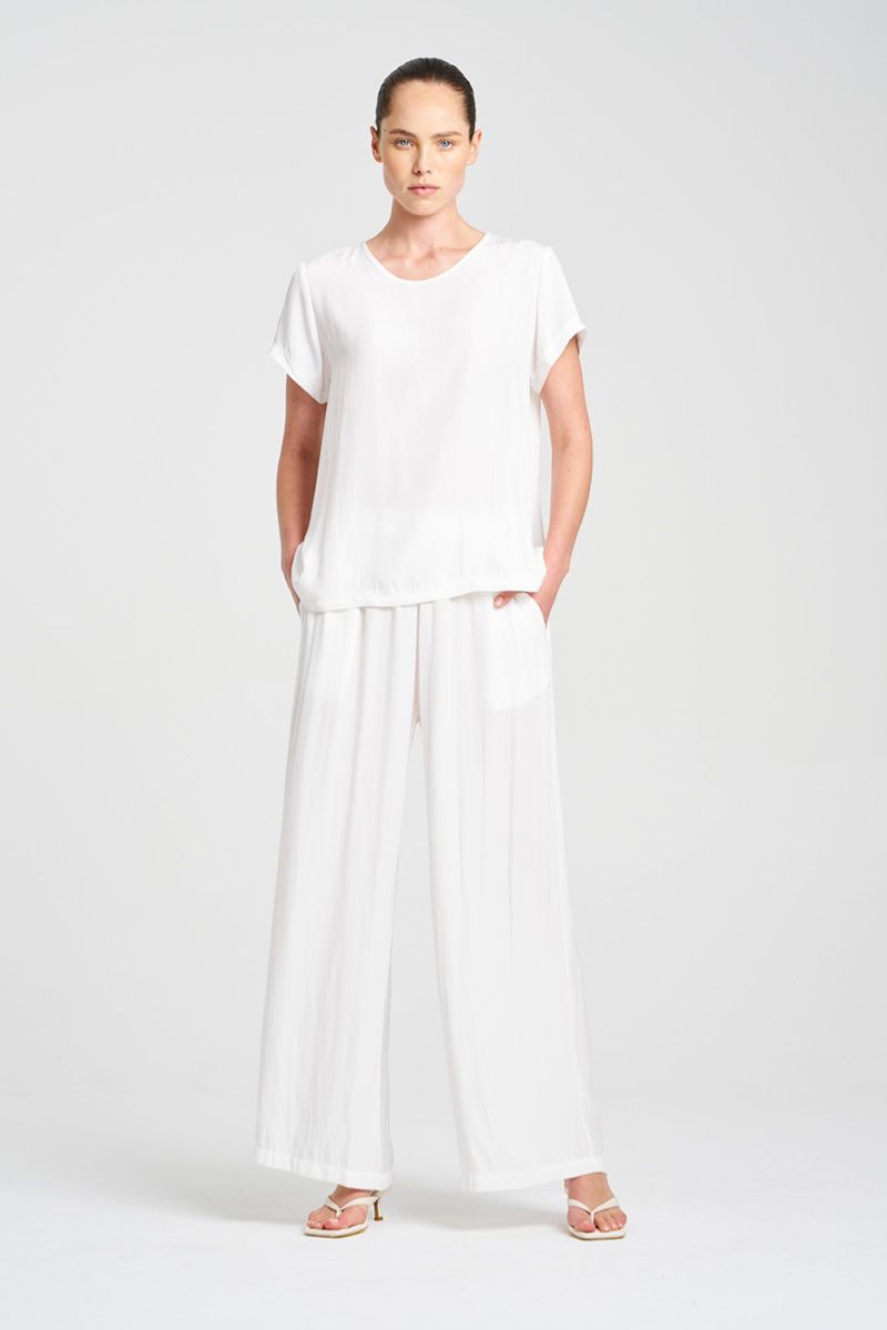 Woman wearing Travel T in Maché F67 2203 by Mela Purdie in White, front view with white trousers.