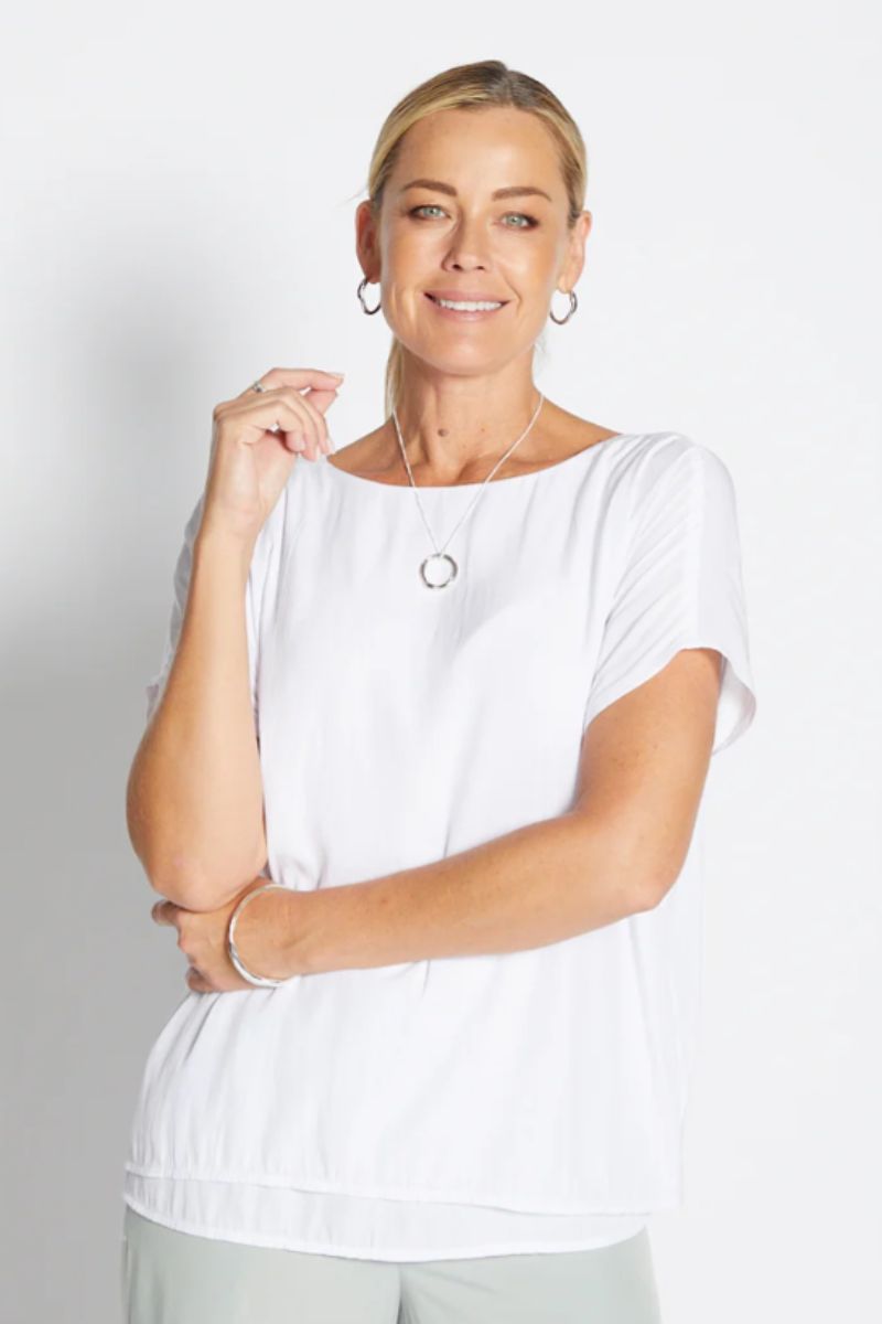 Woman wearing a white blouse with a plain background