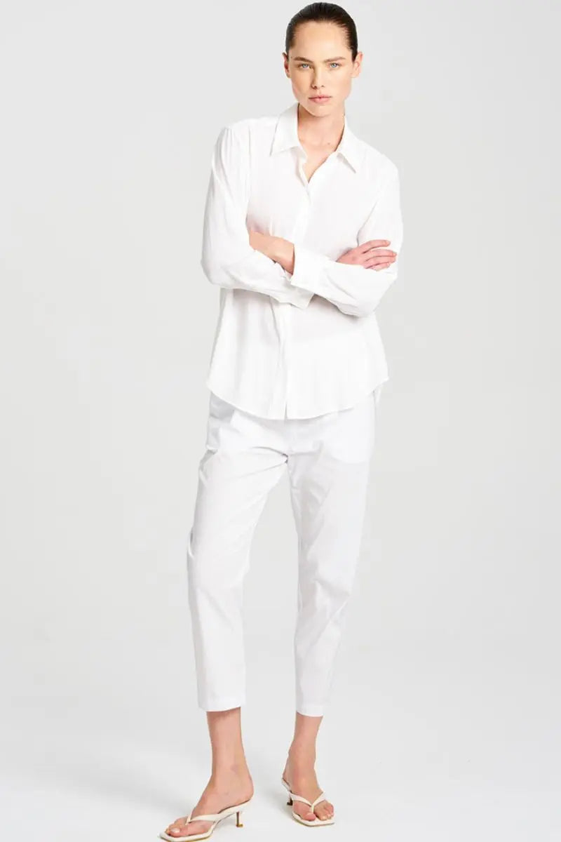 Person wearing a white outfit on a plain background