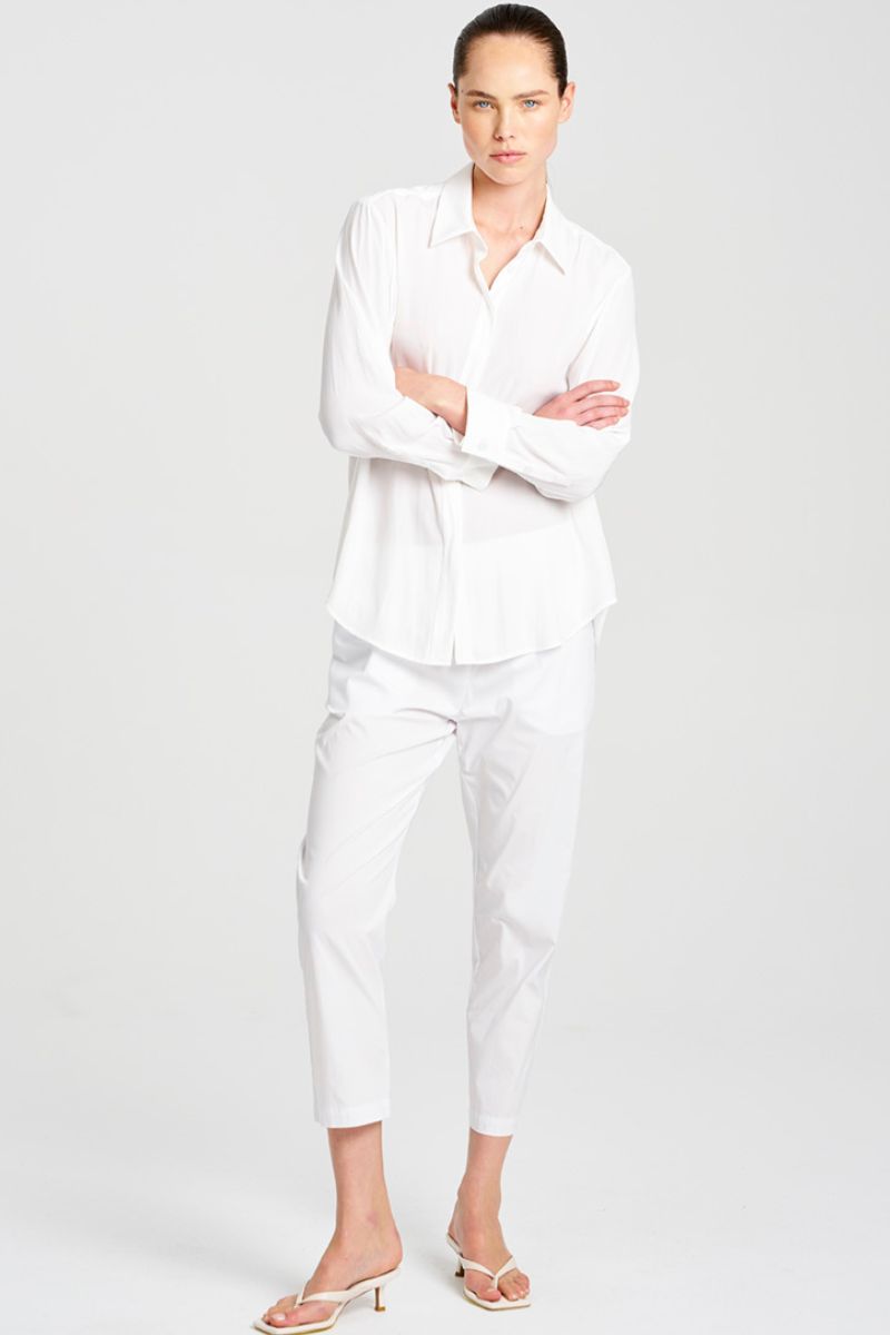 Person wearing a white outfit on a plain background