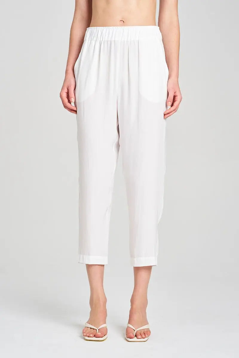 White pants worn by a person on a plain background