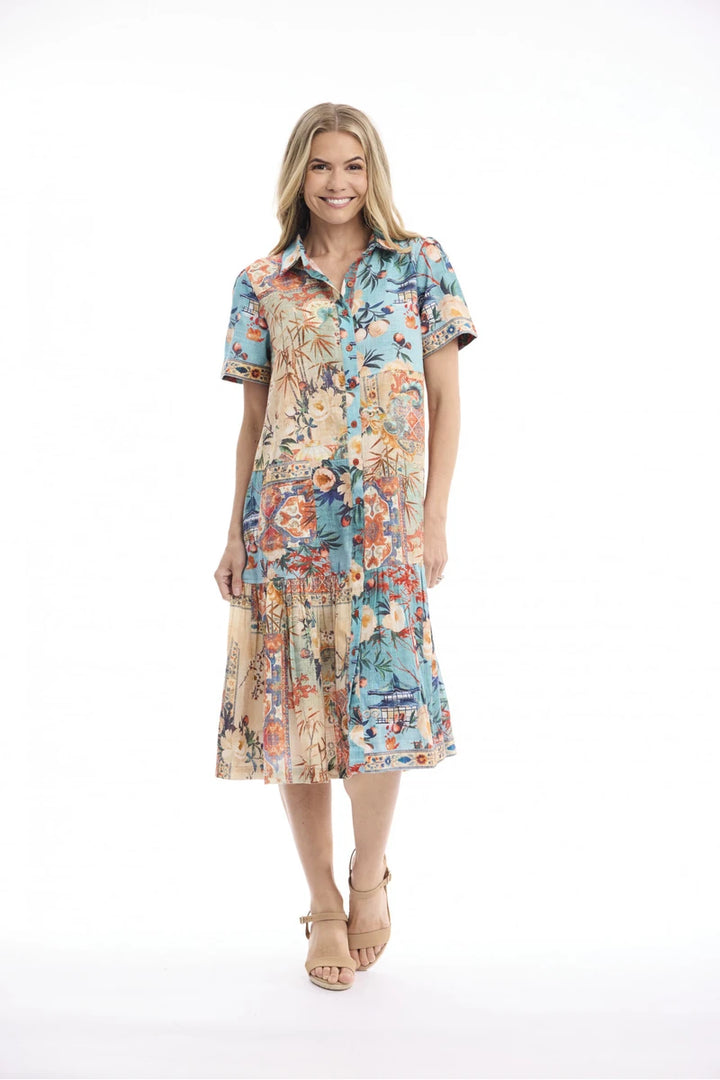 Woman wearing Orientique Gordes Patch Long Dress Print 21860 front view with button-through collar, patch pocket and gathered skirt