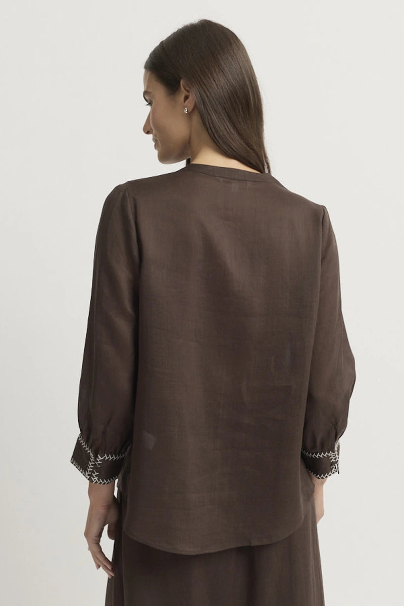 Back model view showing the clean back, regular shoulder line, three-quarter sleeves, embroidered cuffs and curved back hem