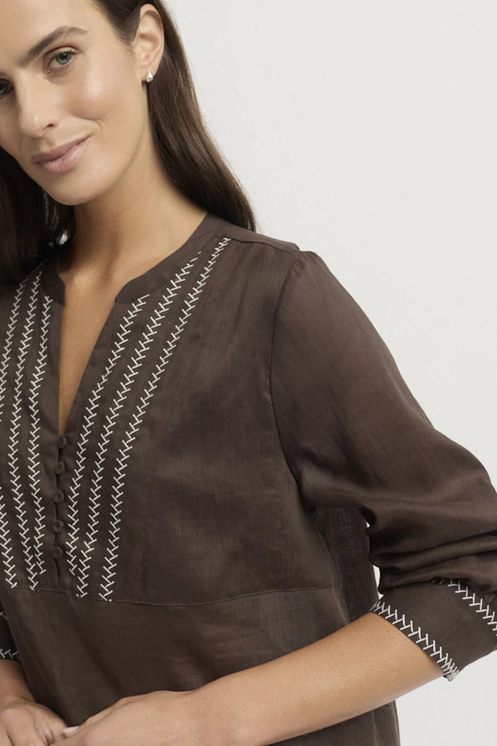 Close-up showing the Grace Blouse V neckline, tonal buttons and contrasting stitched embroidery across the front panel and sleeve cuffs.
