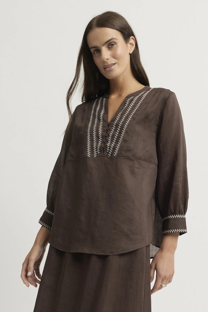 Full front view showing the relaxed shape of the Grace Blouse, embroidered neckline and cuffs, and tonal styling with Coco trousers