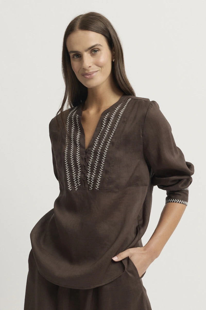 Front model view of the Yarra Trail Grace Blouse in Coco showing the V neckline, contrast embroidered front panel, three-quarter sleeves and curved hem.